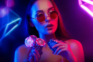 A woman smiling by bright slot machines showing lucky symbols, showcasing the exciting slot offerings at JAYA.